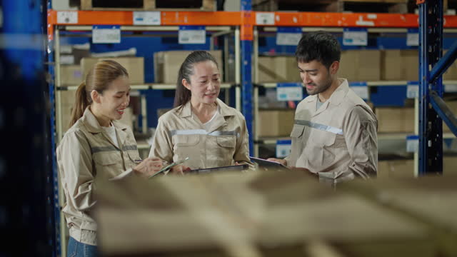 Female Inventory Manager Shows Digital Tablet Information to a Worker,They Talk and Do Work.In the Background Stock of Parcels with Products Ready for Shipment.