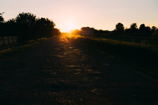 Damaged asphalt pavement road with potholes on sunlight