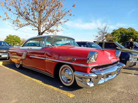 Buenos Aires, Argentina – May 29, 2023: View of an old red 1955 Ford Mercury Montclair two-door hardtop in a parking lot.