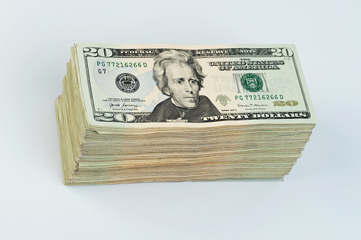 Tax money stack theme. Twenty dollar bill pile isolated on white studio background