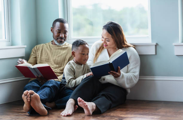 istock Little boy distracts parents from reading books 1558585715