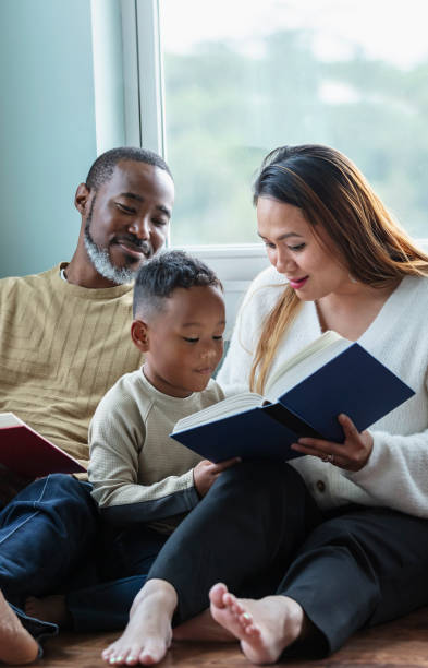 istock Little boy distracts parents from reading books 1558586014
