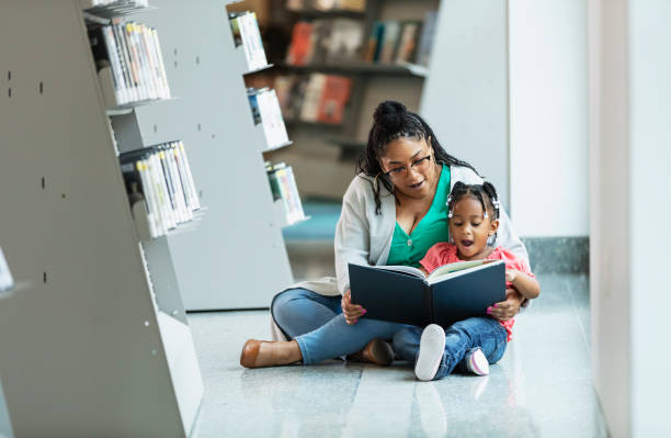 도서관에서 어머니와 함께 책을 읽고 있는 혼혈 소녀 - picture book library preschool bookshelf 뉴스 사진 이미지