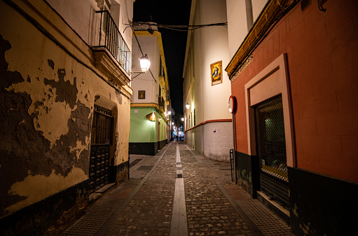 Night time shot of Cadiz city streets with beautiful streetlamps and old buildings.
