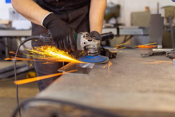 istock Employee with Grinder in Manufacturing Facility 1558602694
