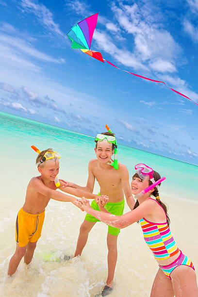 istock Children flying kite in sea 155863929