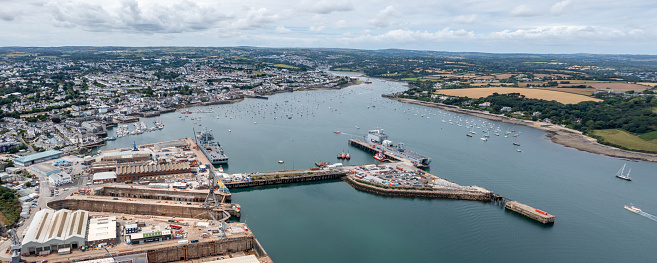 Falmouth, Cornwall, UK - July 5, 2023.  Aerial landscape panorama view of the docks and harbour in Falmouth with Royal Navy fleet auxillary ships docked for resupply