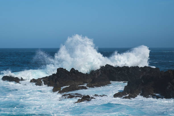istock ocean waves crashing on rocks during windy weather 1558664338