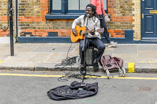 London, UK, 23 May 2023: A Man guitarist performing at the Columbia Road Flower Market, a street market in East London that is open every Sunday