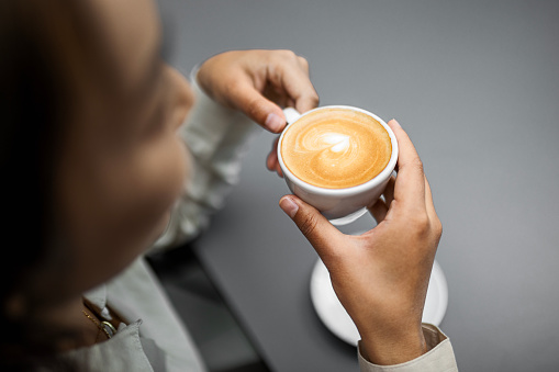 Smiling Chinese woman drinking coffee