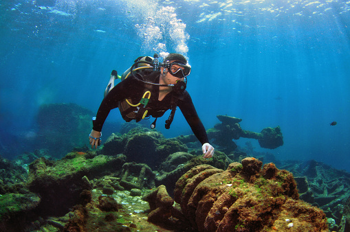 A man doing scuba diving near a shipwreck