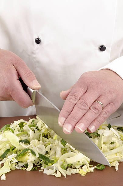 istock female chef cuts cabbage with a large knife 155878835