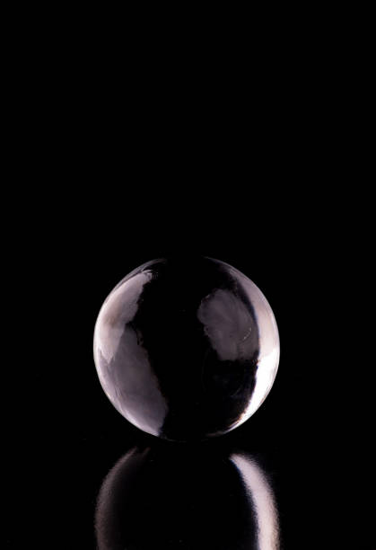 istock crystalline translucent ice and crystal sphere isolated on black background with reflection from the front 1558806867