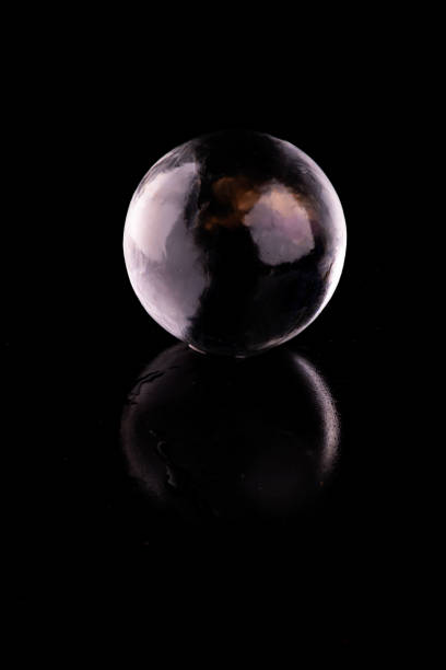 istock crystalline translucent ice and crystal sphere isolated on black background with reflection 1558806870