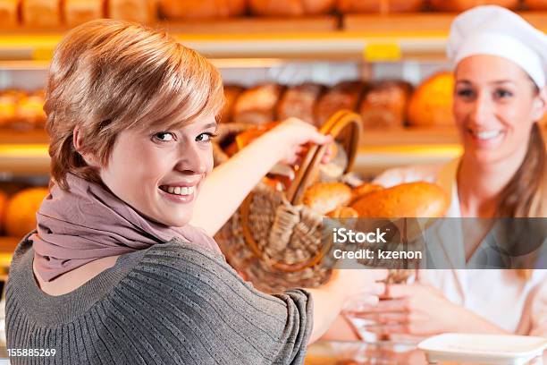 Venditore Con Cliente Femminile In Panetteria - Fotografie stock e altre immagini di Adulto - Adulto, Baguette, Berretto