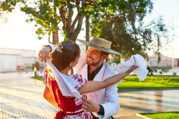 retrato hombre latinoamericano abraza a una mujer vestida de huaso bailando cueca en la plaza del pueblo - men latin american and hispanic ethnicity young men smiling fotografías e imágenes de stock