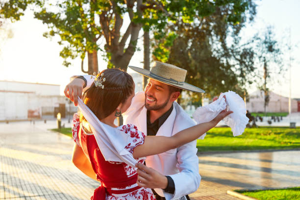 portrait latin american man hugs a woman dressed as huaso dancing cueca in the town square stock photo