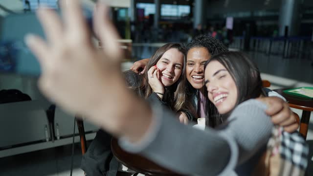 Friends using phone at the airport