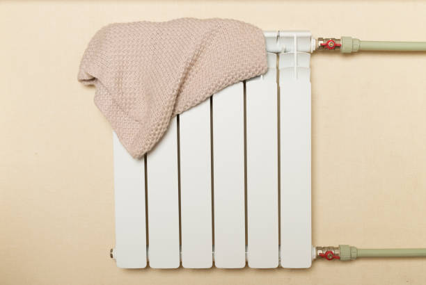 istock Bimetallic radiator with hat indoors. Winter heating concept 1558923423