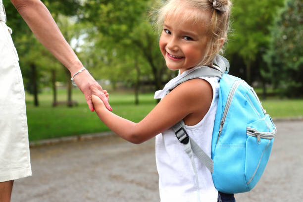 istock Kid girl with blue backpack going to school, lifestyle staging 1558928244
