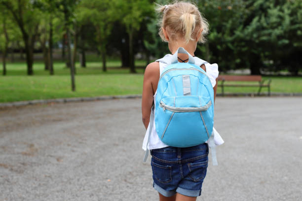 istock Kid girl with blue backpack going to school, lifestyle staging 1558928249