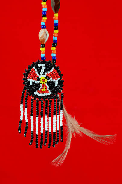 Beaded Thunderbird Symbol Native American Thunderbird symbol handcrafted of beads, shells, feathers on red background symbol north american tribal culture bead feather stock pictures, royalty-free photos & images