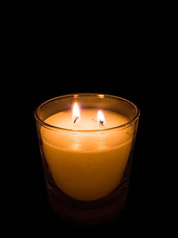 Yellow candle with two burning flames