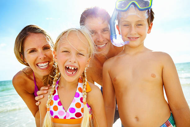 istock Backlit happy family in bathing suits on the beach 155900322