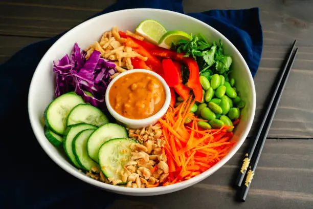 Vegan salad of rice noodles topped with edamame, carrots, and other fresh vegetables