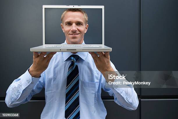 Sonriente Joven Hombre De Negocios Sosteniendo Portátil Con Cara En Pantalla Foto de stock y más banco de imágenes de 30-39 años