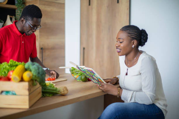 istock Young black couple looking for recipes in cookbook 1559050882