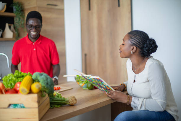 istock Young black couple looking for recipes in cookbook 1559077554