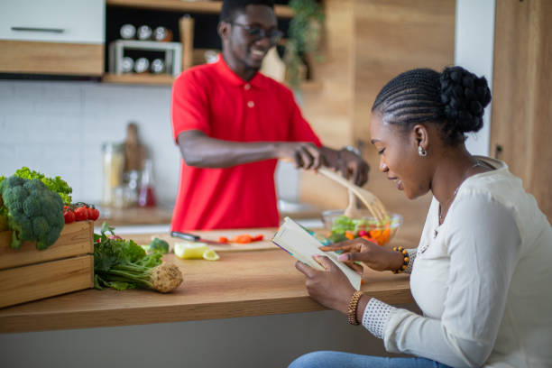 istock Young black couple looking for recipes in cookbook 1559078060