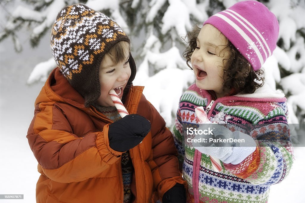 Encantadores niña y niño jugando en la nieve Riendo juntos - Foto de stock de Nieve libre de derechos
