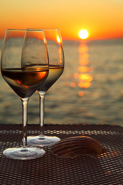 istock Glasses of wine against red sunset 155908048