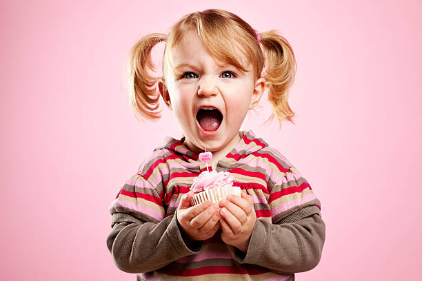 ładny litte dziewczyna brudny śmiać się i przytrzymanie różowy urodziny ciastko - cupcake cake birthday candy zdjęcia i obrazy z banku zdjęć