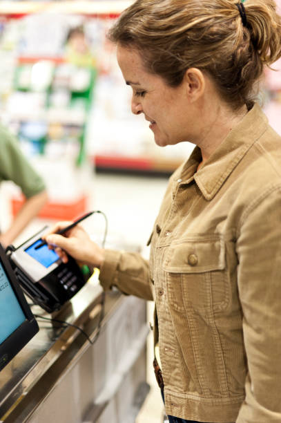 istock Mature woman electronic signing her bill 155908338