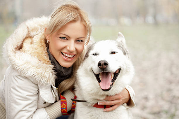 Little girl hugs friendly husky.Focus is on dog.