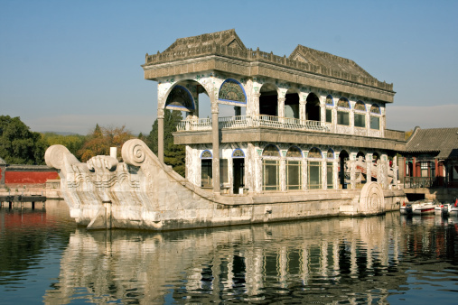 Marble boat in Summer Palace compound at sunrise with water reflections. Beijing. China. 