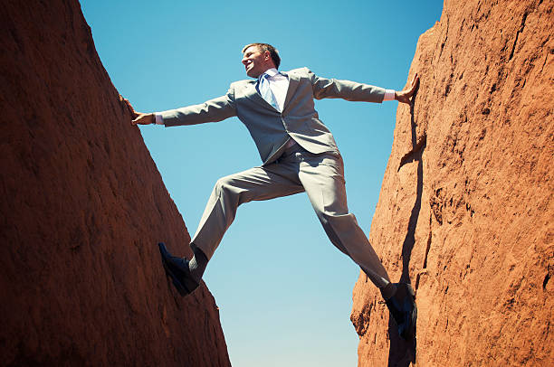 istock Stuck Businessman Standing Outdoors Wedged between Two Rock Walls 155908620