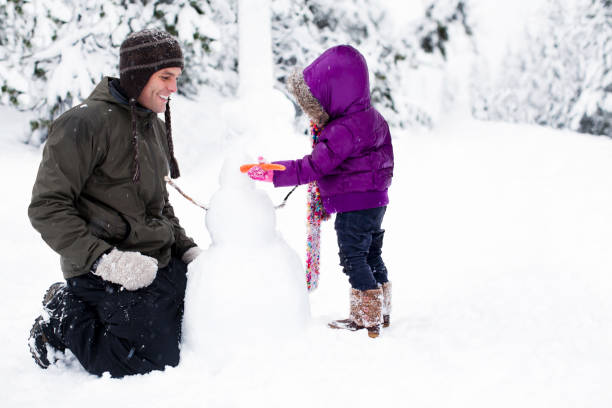 istock Adorable Little Daughter Building Snowman with Dad, Copy Space 155908783