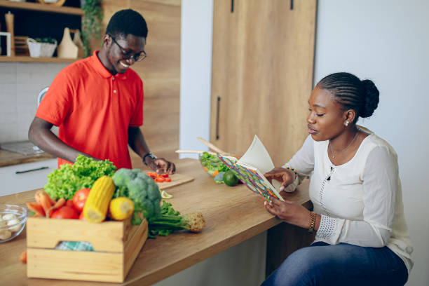 istock Young black couple looking for recipes in cookbook 1559089972