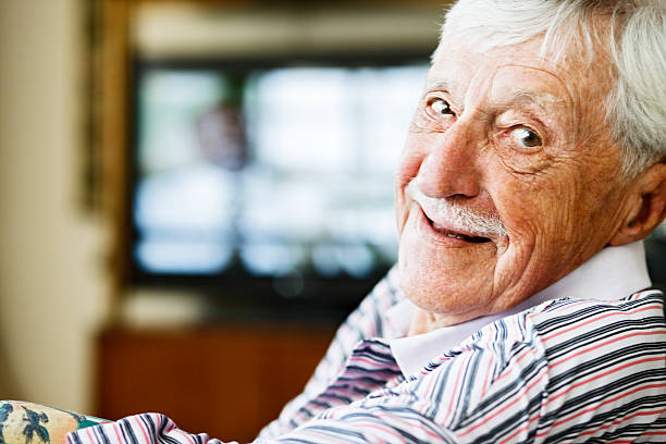 istock Cheerful old man looks over shoulder from watching television 155909077