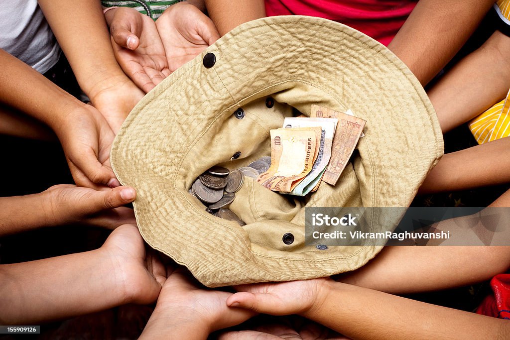 Mains d'enfants collecte de l'argent don à une œuvre caritative à chapeau - Photo de Don caritatif libre de droits