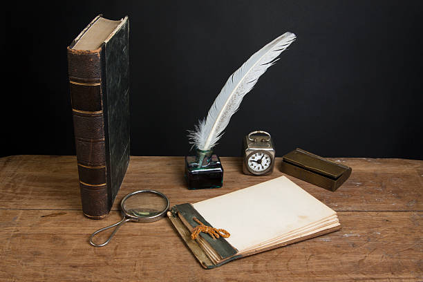 istock Old notepad, quill, inkwell, book, magnifying glass, clock on table 155911021