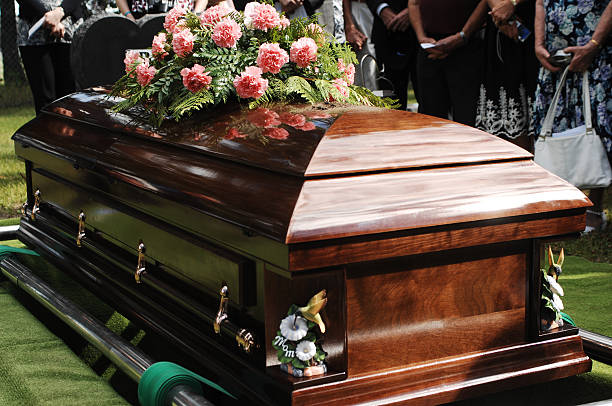 Coffin at a funeral service in a cemetery A coffin about to be lowered at a funeral service in a cemetery. funeral stock pictures, royalty-free photos & images