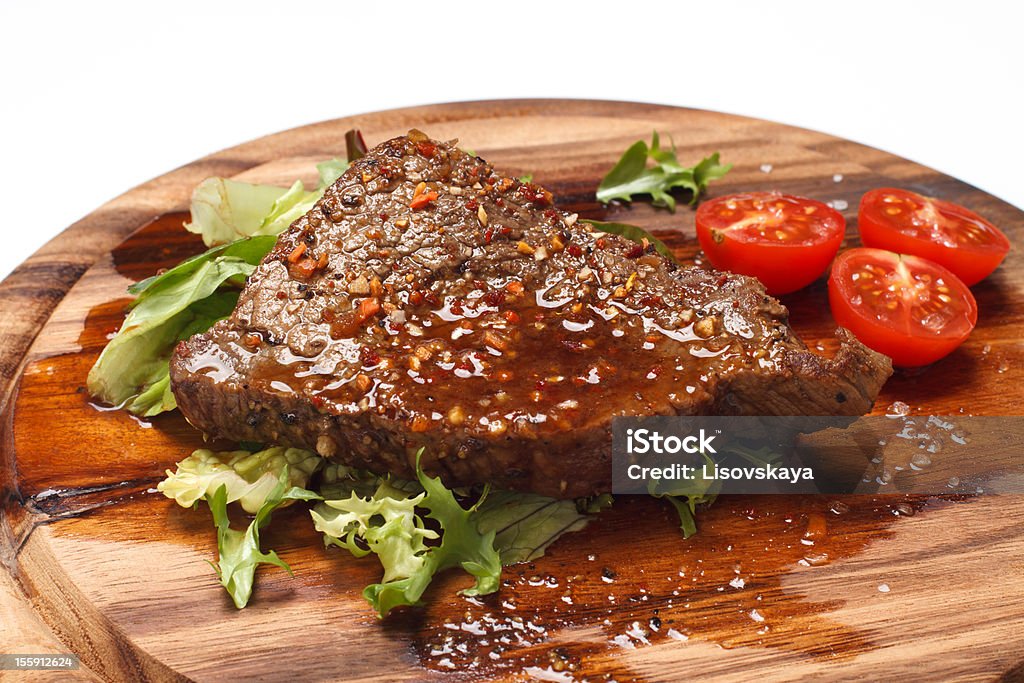 Bistec sobre fondo de madera - Foto de stock de Alimento libre de derechos