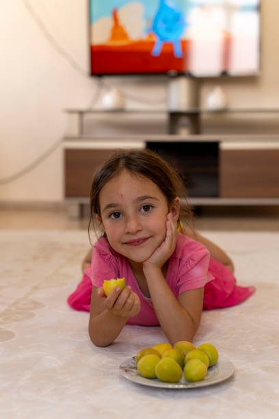 istock Girl eating fruit. 1559139167