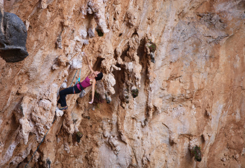 Caucasian female rock climber on a cliff face