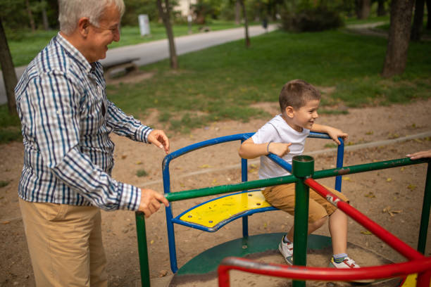 istock Boy with grandpa in park playground 1559200678